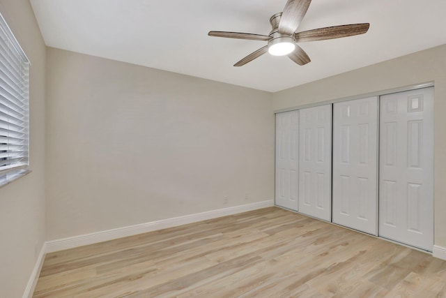 unfurnished bedroom with ceiling fan, light wood-type flooring, and a closet