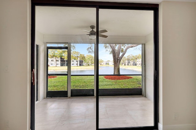 doorway featuring ceiling fan and a water view