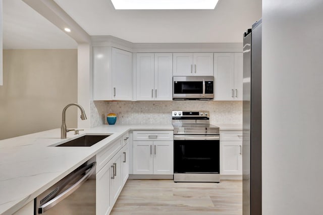 kitchen featuring white cabinets, sink, and appliances with stainless steel finishes