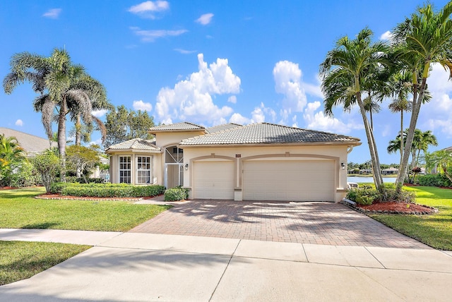 mediterranean / spanish-style house featuring a garage and a front lawn