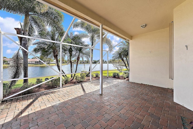 view of patio / terrace with a lanai and a water view