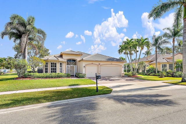 mediterranean / spanish home featuring a front yard and a garage