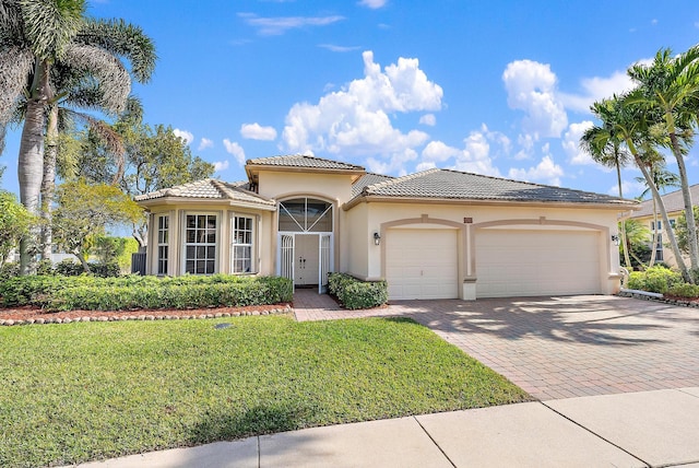 mediterranean / spanish-style home with a garage and a front lawn