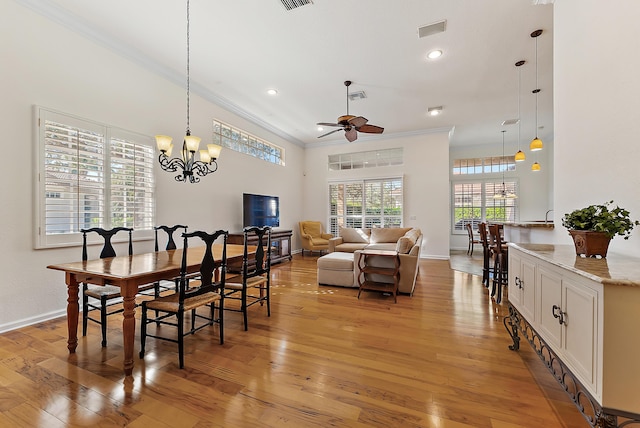 dining room featuring crown molding, ceiling fan with notable chandelier, and light wood-type flooring