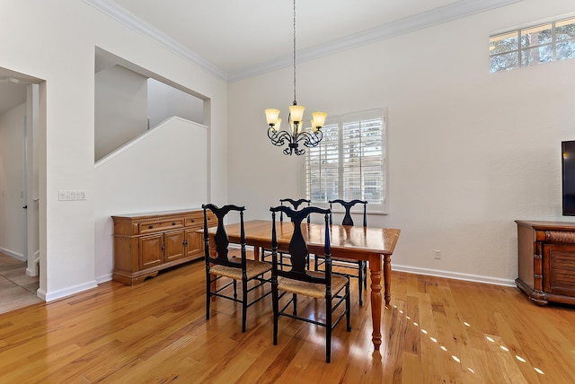 dining room featuring crown molding, a wealth of natural light, a notable chandelier, and light hardwood / wood-style flooring