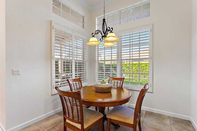 dining space with a notable chandelier, crown molding, and light tile patterned floors