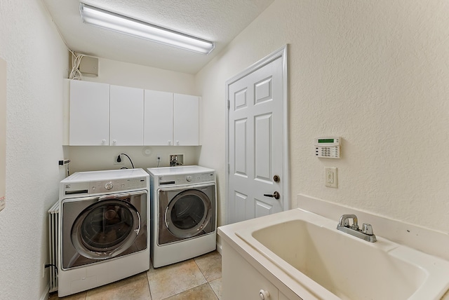 clothes washing area featuring sink, cabinets, independent washer and dryer, a textured ceiling, and light tile patterned flooring