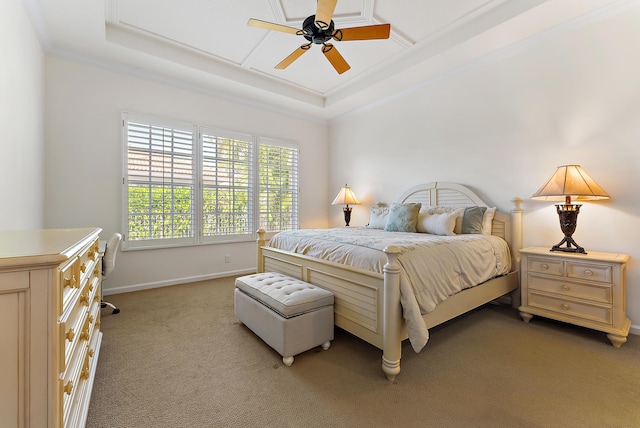 carpeted bedroom featuring a raised ceiling, ornamental molding, and ceiling fan