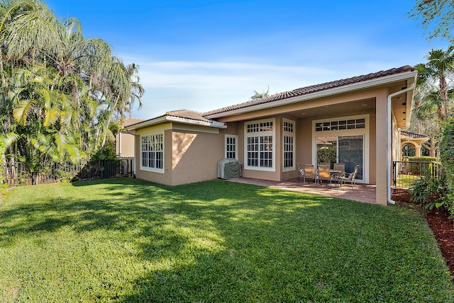 rear view of property with a yard and a patio