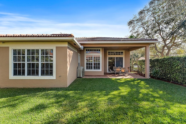 back of property with a patio area and a lawn