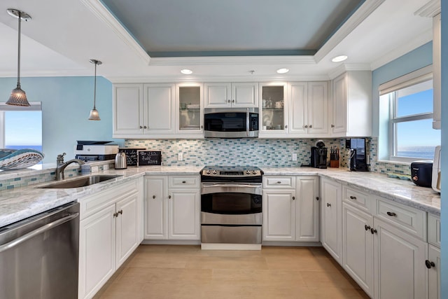 kitchen with sink, pendant lighting, white cabinets, and stainless steel appliances