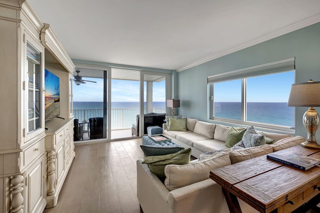 living room featuring light hardwood / wood-style floors, ceiling fan, ornamental molding, and a water view