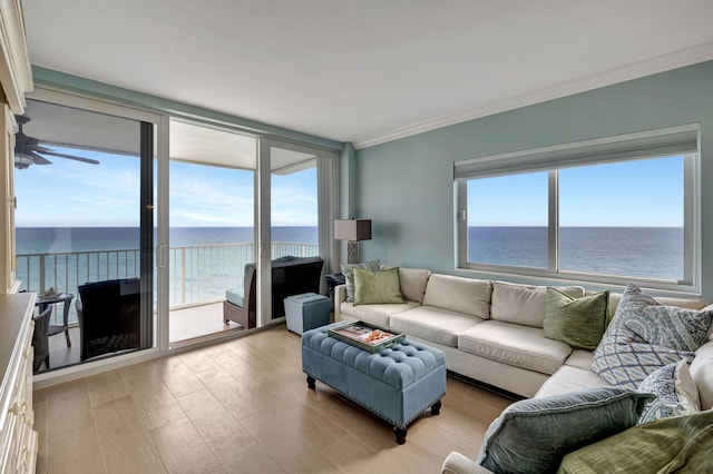 living room with a wealth of natural light, crown molding, a water view, and light hardwood / wood-style flooring