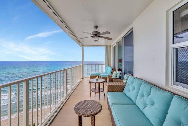 balcony featuring a water view, ceiling fan, and a view of the beach