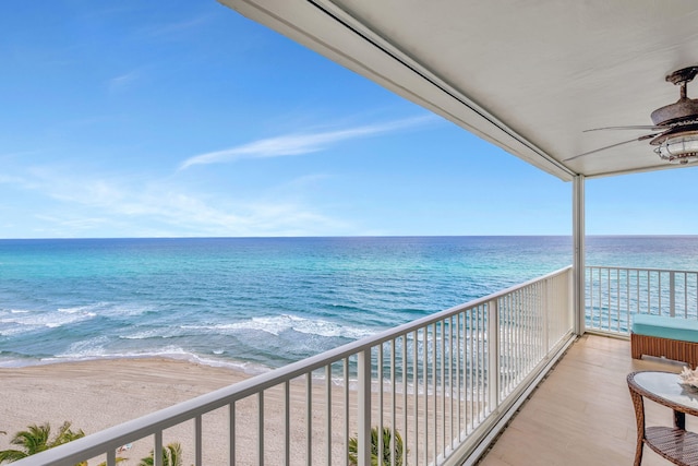 balcony with ceiling fan, a beach view, and a water view