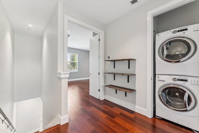 washroom featuring dark hardwood / wood-style floors and stacked washer / drying machine