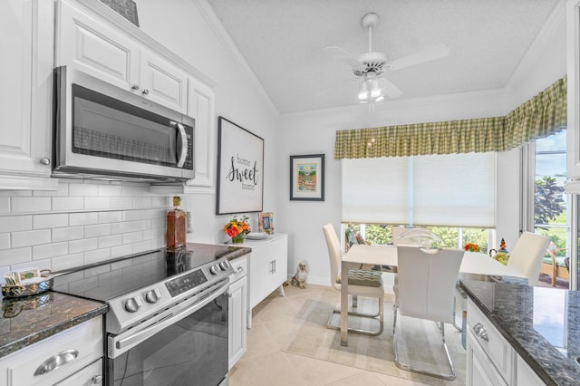 kitchen with white cabinets, stainless steel appliances, and vaulted ceiling