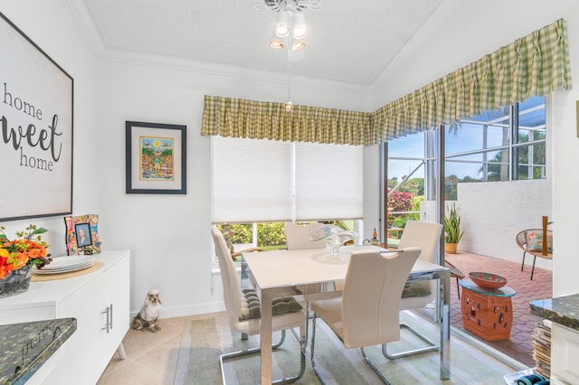 tiled dining area with plenty of natural light, lofted ceiling, and ornamental molding