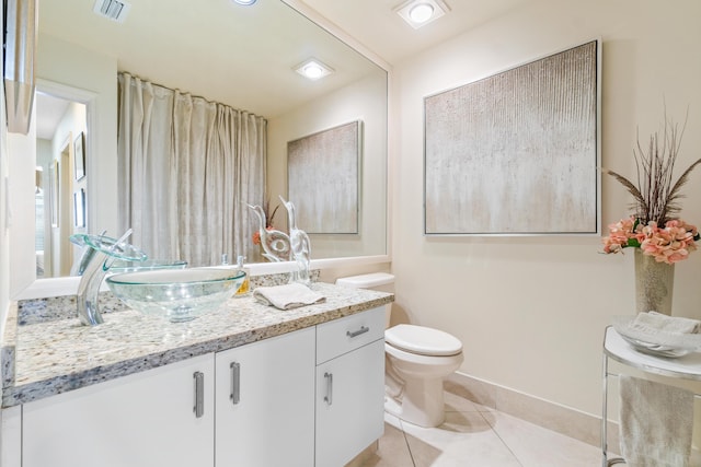 bathroom with tile patterned flooring, vanity, and toilet