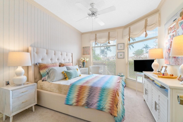 carpeted bedroom featuring ceiling fan and crown molding