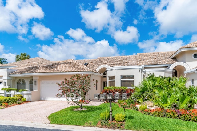 mediterranean / spanish-style home with a front lawn and a garage