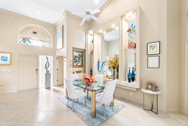 tiled dining room with a high ceiling, ceiling fan, and ornamental molding