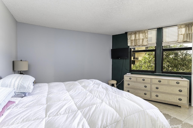 bedroom featuring light tile patterned floors and a textured ceiling