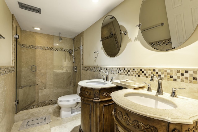 bathroom featuring tile patterned floors, vanity, an enclosed shower, and tile walls