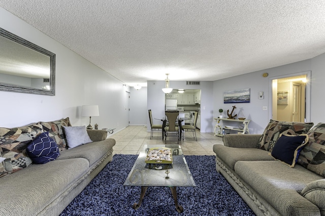 tiled living room featuring a textured ceiling