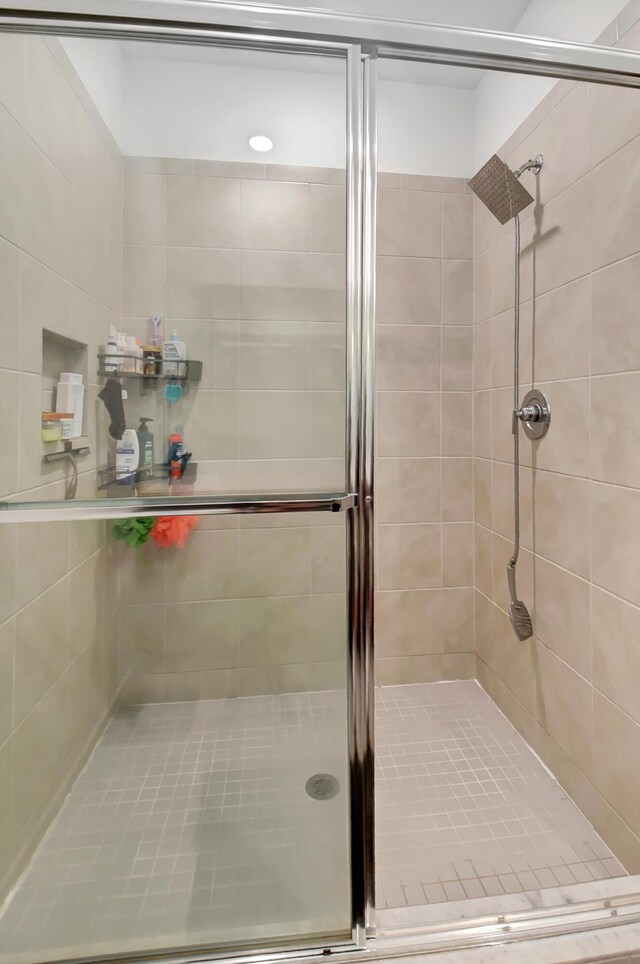 bathroom with tile patterned floors, a shower with door, and vanity