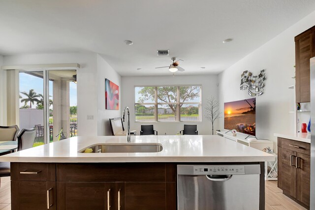 kitchen featuring appliances with stainless steel finishes, ceiling fan, sink, a center island with sink, and light hardwood / wood-style flooring