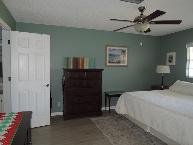 bedroom featuring a textured ceiling, ceiling fan, and dark hardwood / wood-style floors