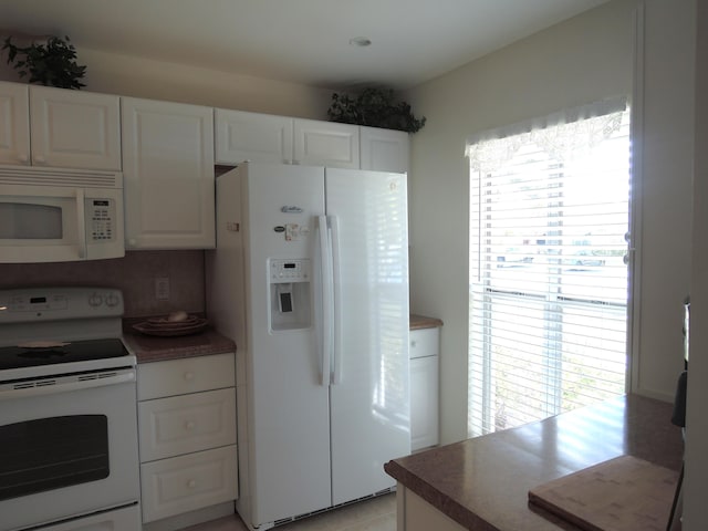 kitchen with decorative backsplash, white cabinetry, light tile patterned floors, and white appliances