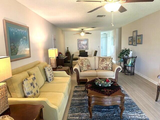 living room featuring wood-type flooring and a textured ceiling