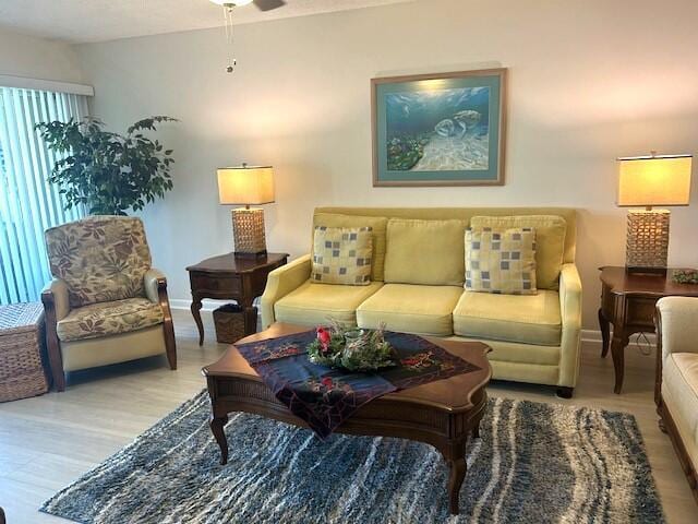 living room featuring ceiling fan and light hardwood / wood-style flooring