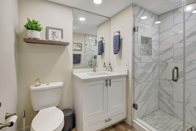 bathroom with vanity, toilet, an enclosed shower, and hardwood / wood-style floors