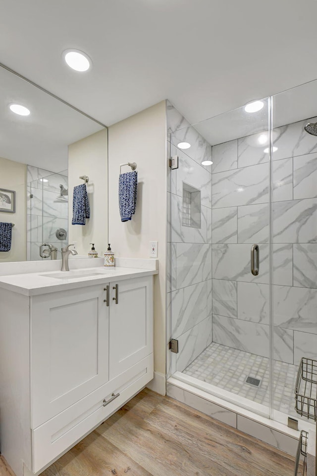 bathroom with vanity, hardwood / wood-style flooring, and walk in shower