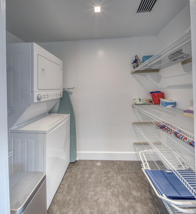 clothes washing area with stacked washer and clothes dryer