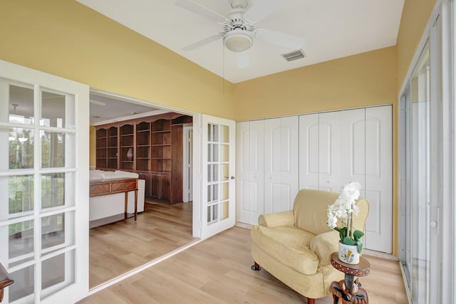 sitting room featuring ceiling fan, french doors, and light hardwood / wood-style floors