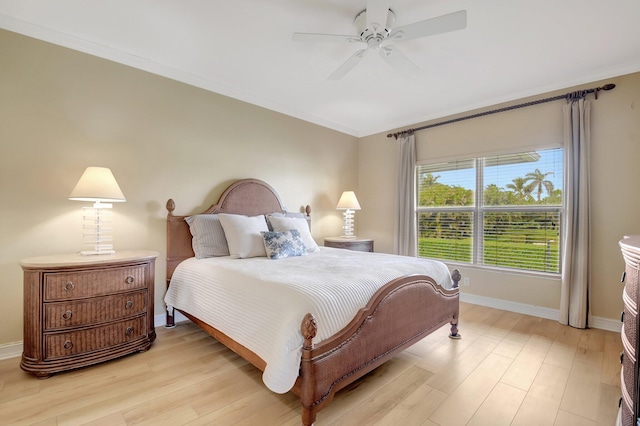 bedroom featuring ceiling fan, ornamental molding, and light wood-type flooring