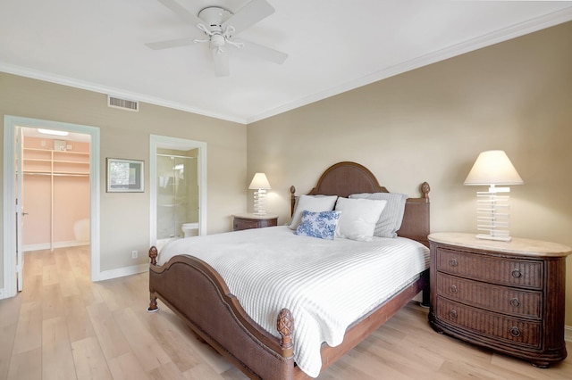 bedroom with ensuite bathroom, a walk in closet, ceiling fan, light wood-type flooring, and a closet