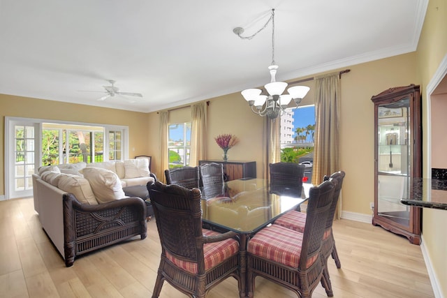 dining area featuring light hardwood / wood-style floors, ceiling fan with notable chandelier, and ornamental molding