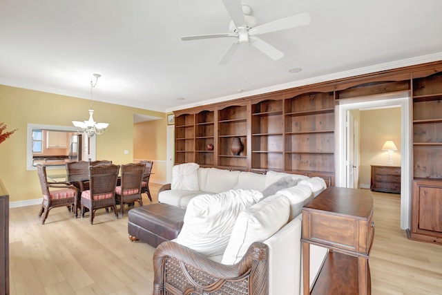 living room with ceiling fan with notable chandelier, light hardwood / wood-style flooring, and crown molding