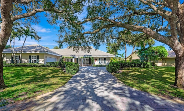 ranch-style house with a garage and a front yard