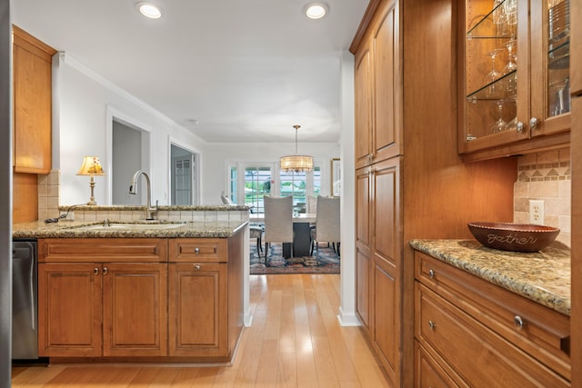 kitchen featuring decorative backsplash, light hardwood / wood-style flooring, dishwasher, and sink