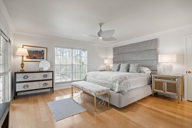 bedroom with hardwood / wood-style floors, ceiling fan, and ornamental molding