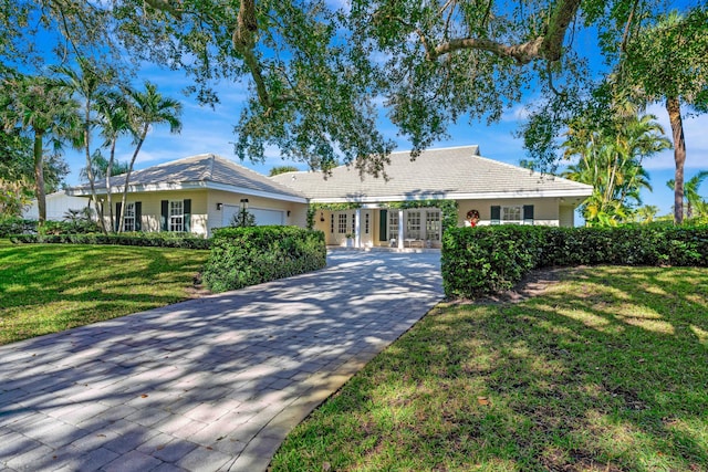 ranch-style home featuring a garage and a front lawn