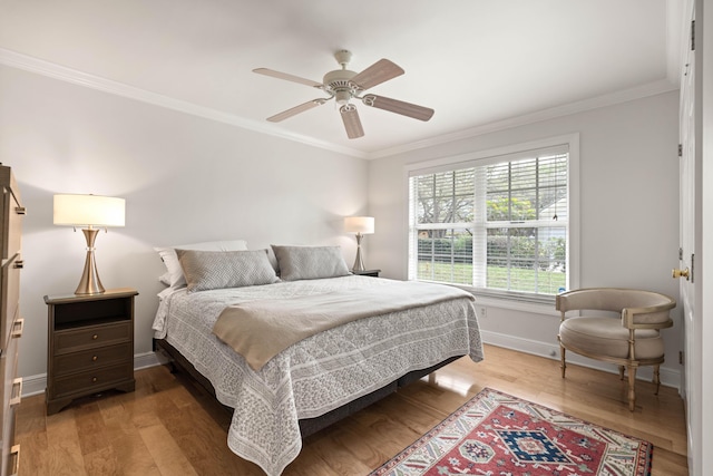 bedroom with ceiling fan, hardwood / wood-style floors, and crown molding