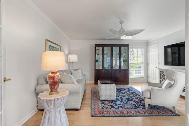 living room featuring light wood-type flooring, ceiling fan, and crown molding