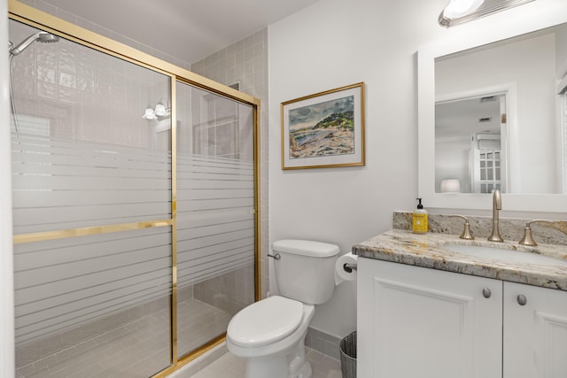 bathroom featuring tile patterned flooring, a shower with door, vanity, and toilet